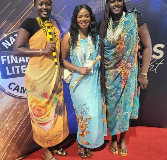 Mimi with two other women in traditional dress in front of a financial literacy banner at the WSB Convention Gala.