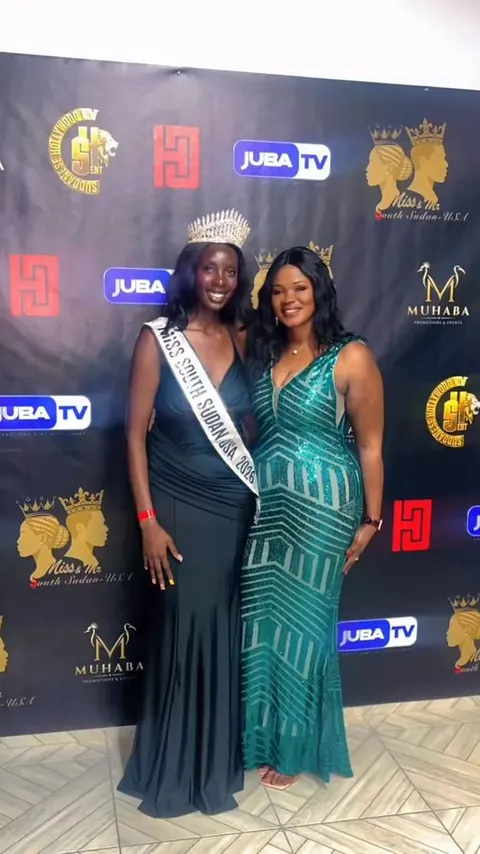 Mimi in a teal gown beside the crowned pageant winner in front of a step-and-repeat backdrop.